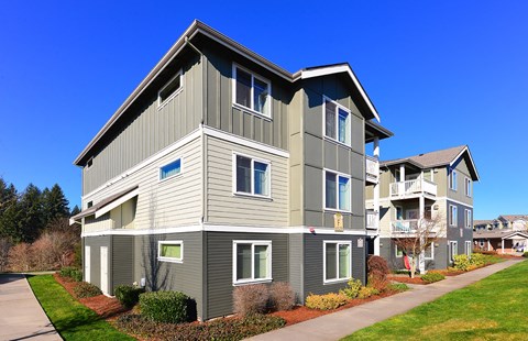an apartment building with a sidewalk in front of it