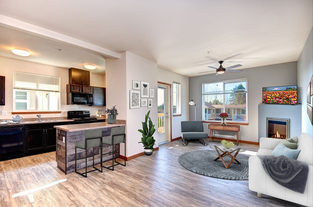 an open living room with a kitchen and a fireplace