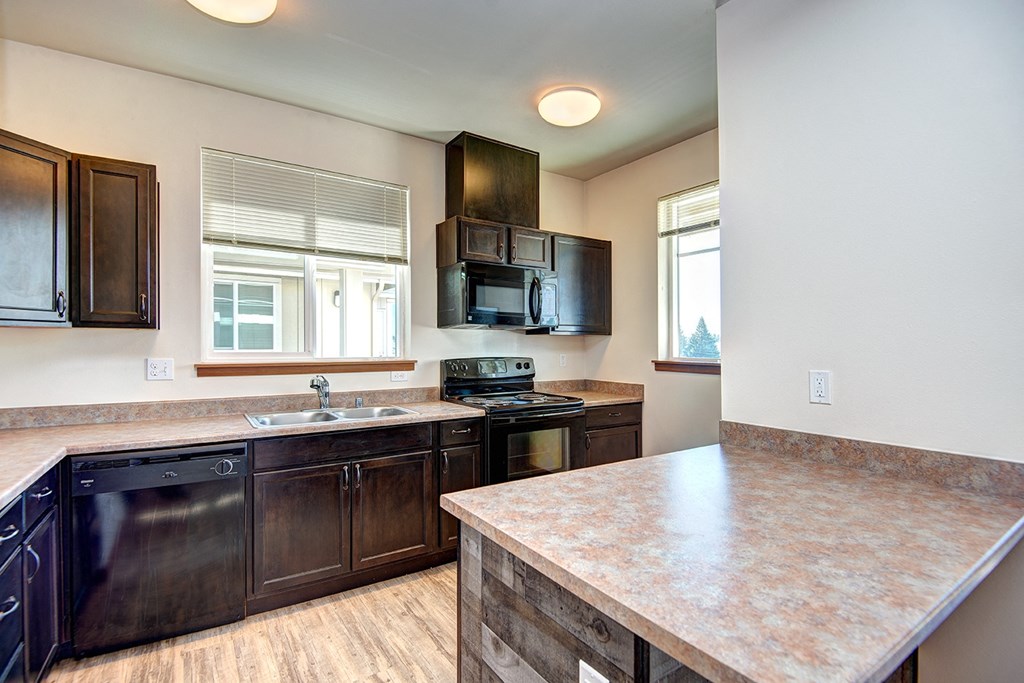 a kitchen with an island and a stove and a sink