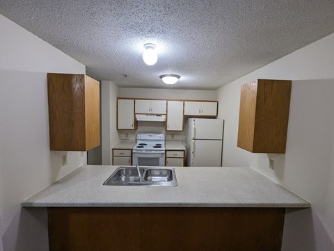 an empty kitchen with a sink and a counter top