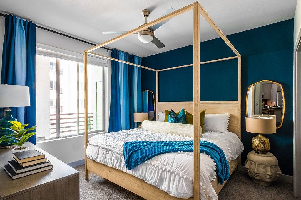 a bedroom with a bed and a blue wall and a gold canopy bed