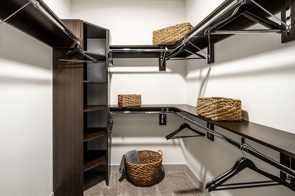 a large walk in closet with shelves and baskets