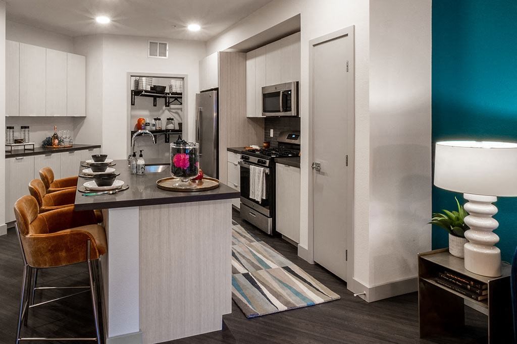 a kitchen and living room with a counter and a refrigerator