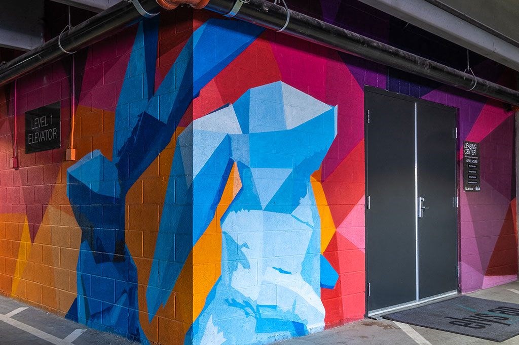 a wall painted with colorful geometric shapes and a door