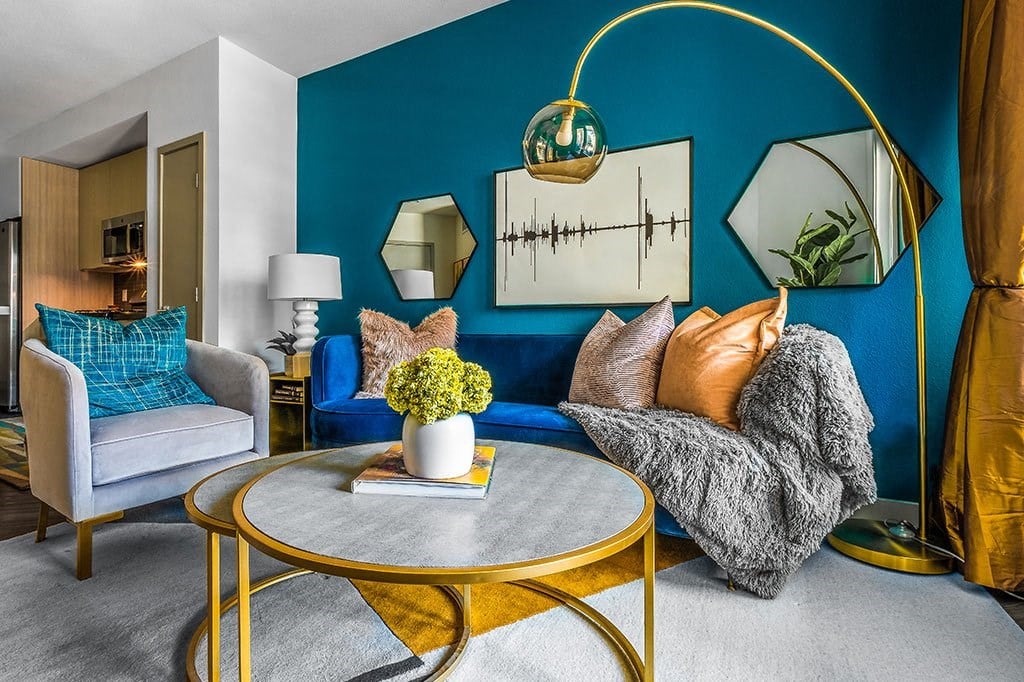 a living room with blue walls and gold furniture