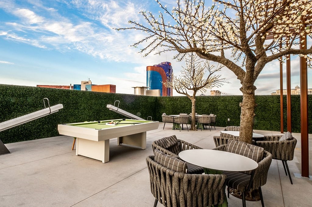 a terrace with tables and chairs and a pool table