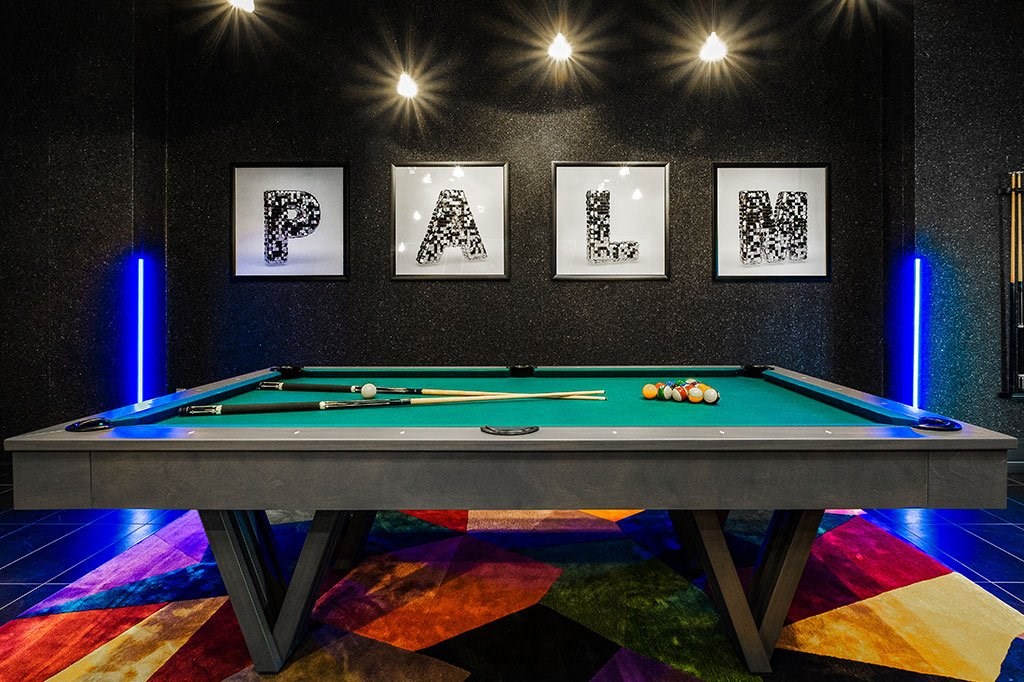 a pool table in a billiards room with pictures on the wall