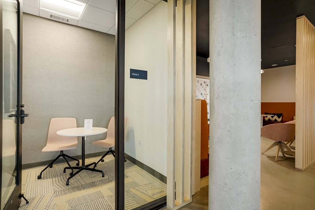 a conference room with glass doors and a table and chairs