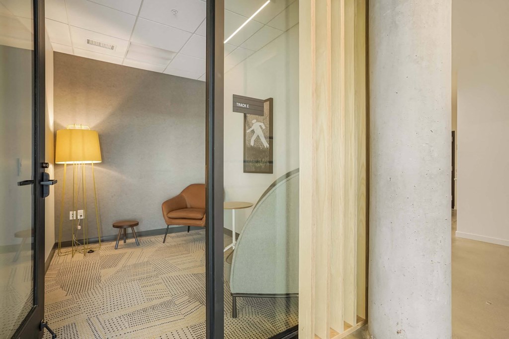 a glass wall in a room with a glass table and a chair