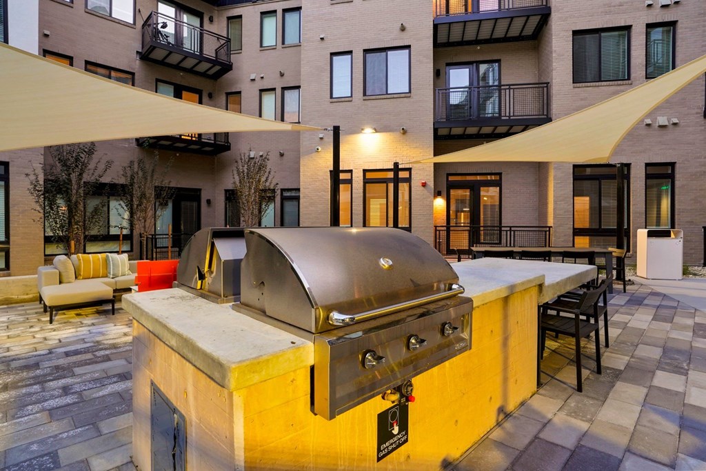 Pet-Friendly Apartments In Wheat Ridge, CO - The Parallel - Grill Area With BBQs, Couches, Tables, And Chairs