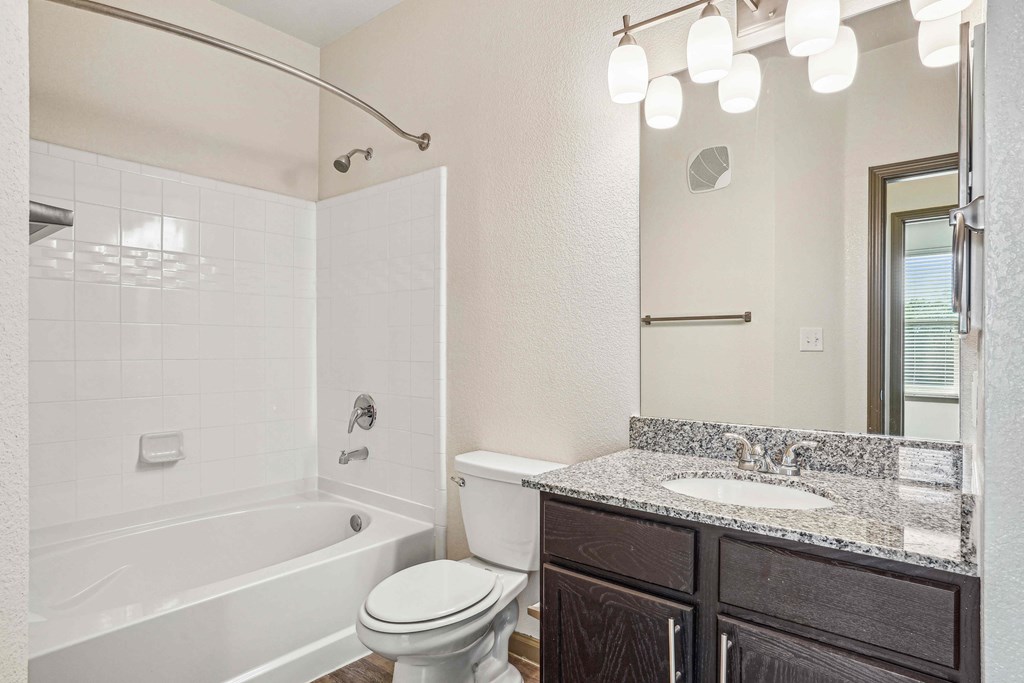 Pet-Friendly Rentals in Bentonville, AR – Parc at Bentonville – A white bathroom with a toilet, sink, and bathtub.