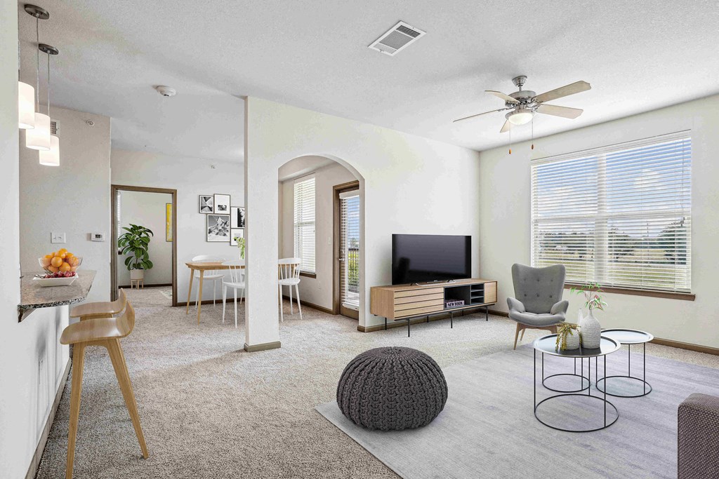 1 & 2-Bedroom Apartments for Rent in Bentonville, AR – Parc at Bentonville – A living room with a television, chairs, and a table.