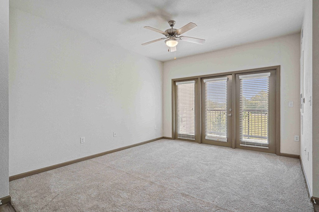 Pet-Friendly Rentals in Bentonville, AR – Parc at Bentonville – A room with a ceiling fan and sliding glass doors.