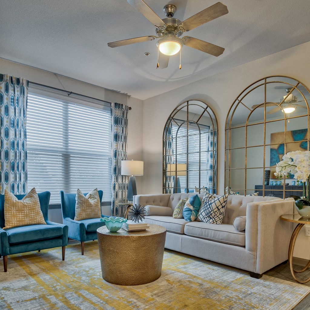 Living room with couch and windows at Parc at Bentonville Apartments in Bentonville, AR