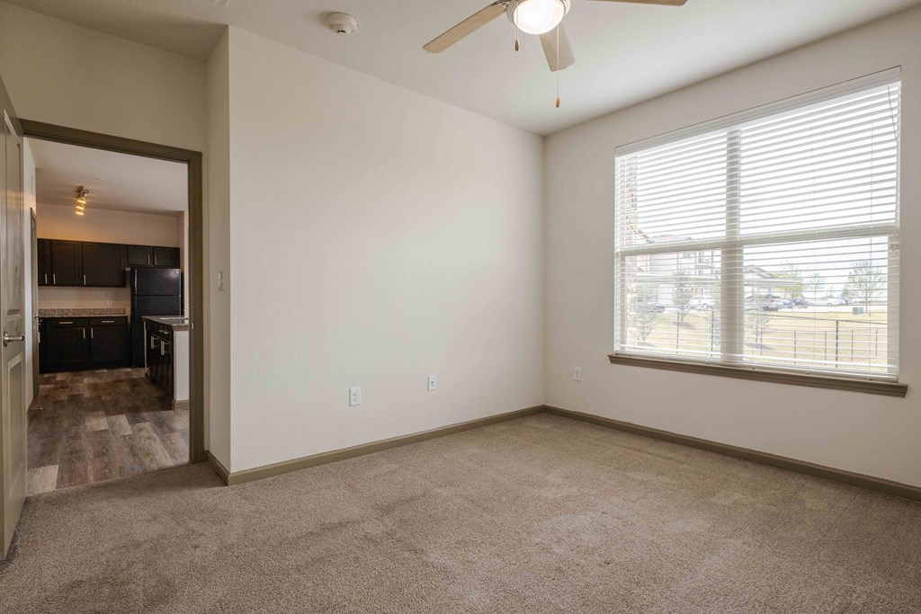 a bedroom with carpet and ceiling fan and window with blinds