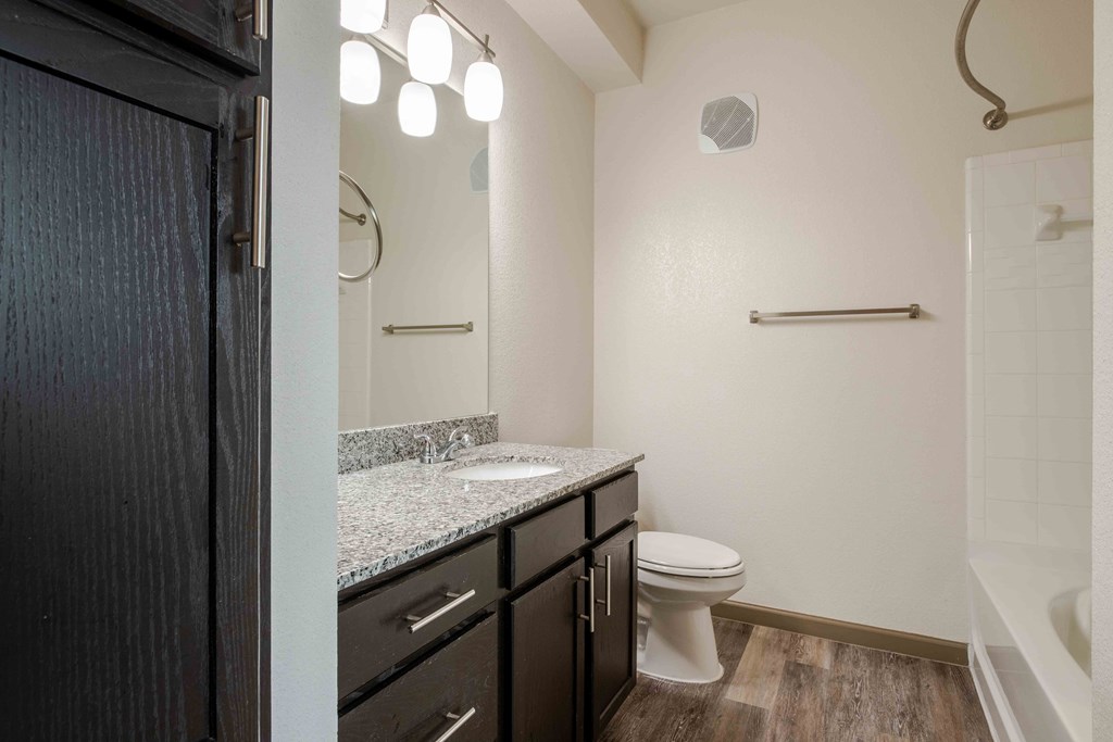 a bathroom with a toilet, sink and bathtub at Parc at Bentonville Apartments in Bentonville, AR