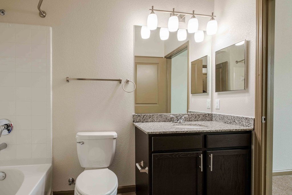 a bathroom with a toilet sink and bathtub at Parc at Bentonville Apartments in Bentonville, AR