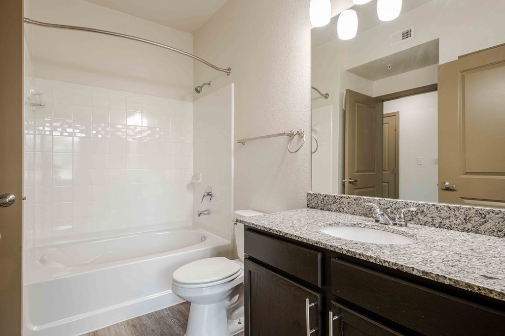 a bathroom with a toilet sink and bathtub at Parc at Bentonville Apartments in Bentonville, AR