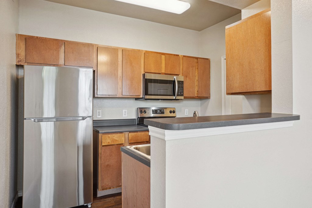 Pet-Friendly Rentals in Maumelle, AR – Parc at Maumelle – A kitchen with a refrigerator, microwave, and countertop.