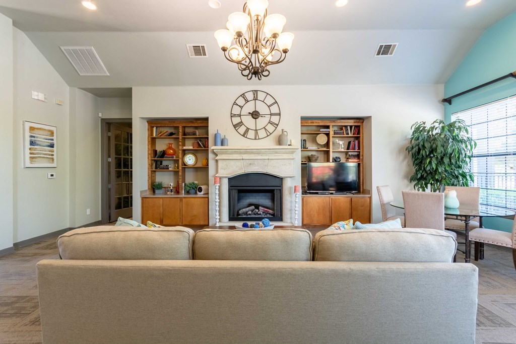 Club house with ceiling light and couches and windows