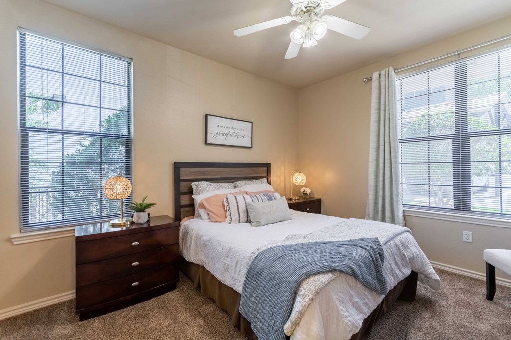 Bedroom with carpet floor and ceiling fan and windows