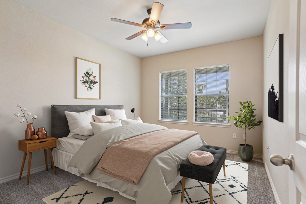 1, 2 & 3-Bedroom Apartments for Rent in Rogers, AR – Parc at Rogers– A bedroom with a bed, a chair, and a ceiling fan.