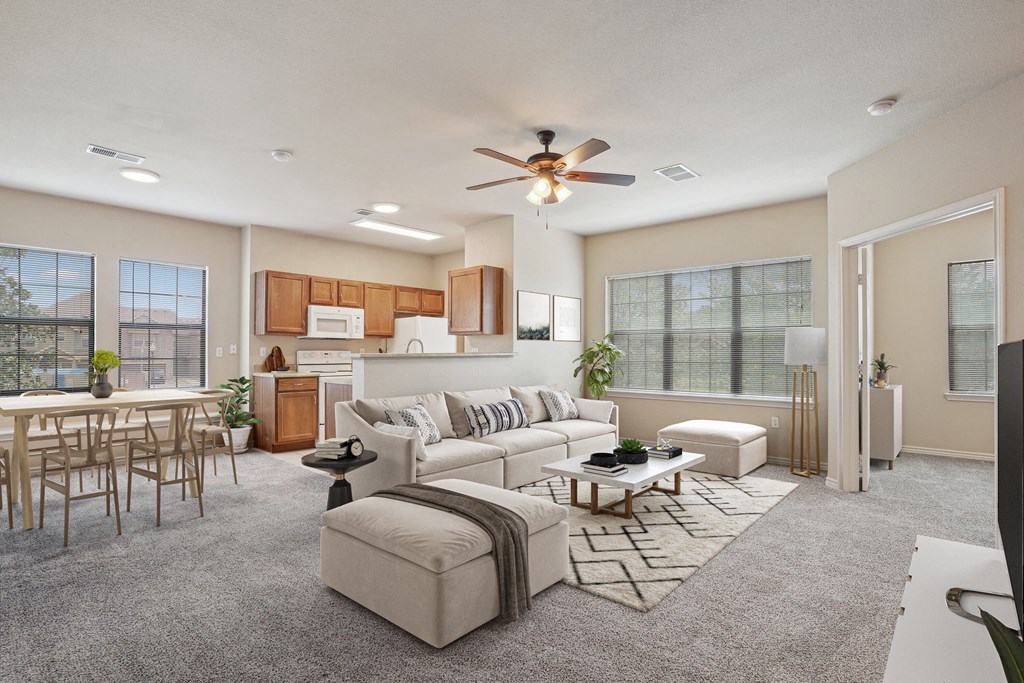 1, 2 & 3-Bedroom Apartments for Rent in Rogers, AR – Parc at Rogers– A living room with a white couch and a wooden dining table.