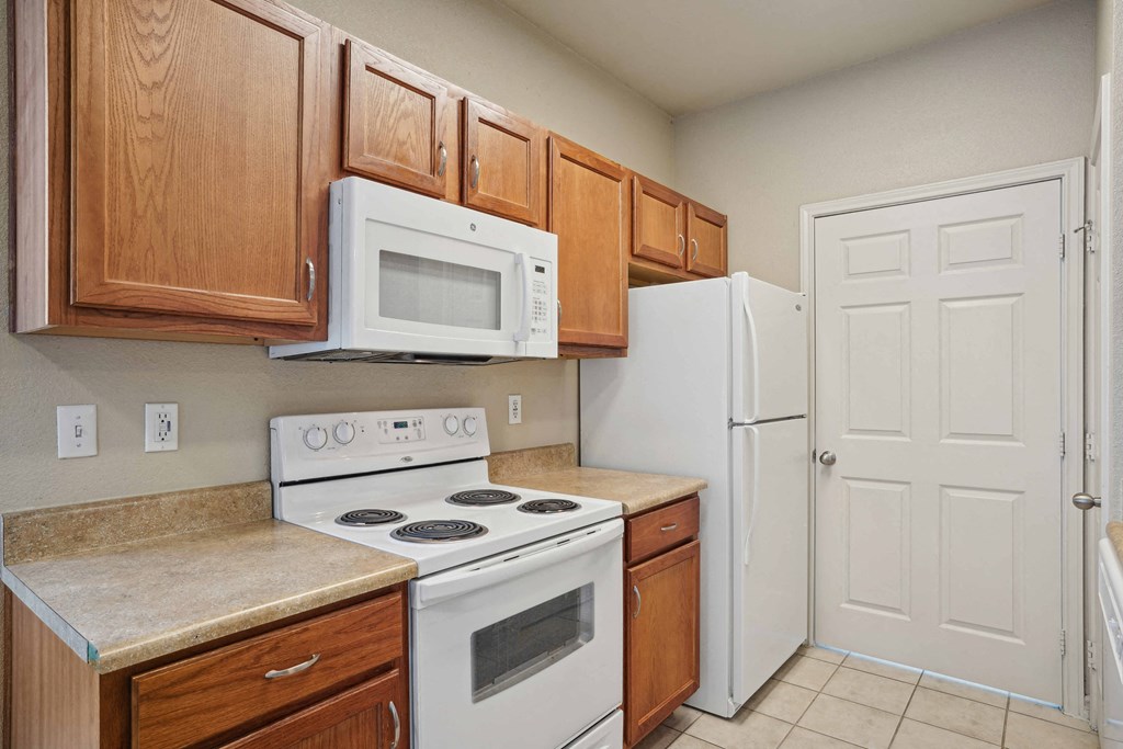 Pet-Friendly Rentals in Rogers, AR – Parc at Rogers – A kitchen with a white stove and white refrigerator.
