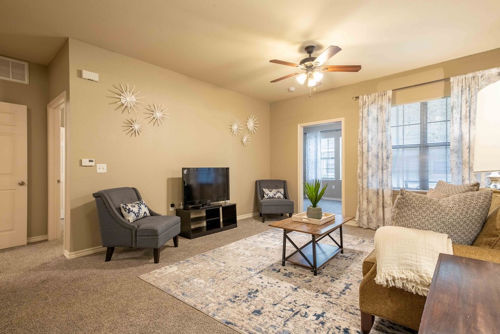 bedroom with a ceiling light/fan and carpet and doors and windows