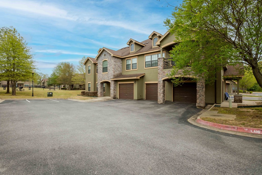 Pet-Friendly Rentals in Rogers, AR – Parc at Rogers – apartment building with a drive way in the front and garages