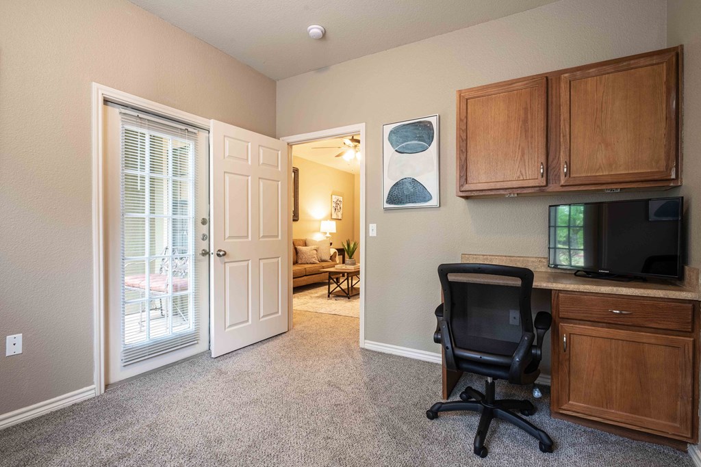 Apartments for Rent in Rogers, AR 72758– Parc at Rogers-  room with a desk and chair and cabinets and carpet and doors