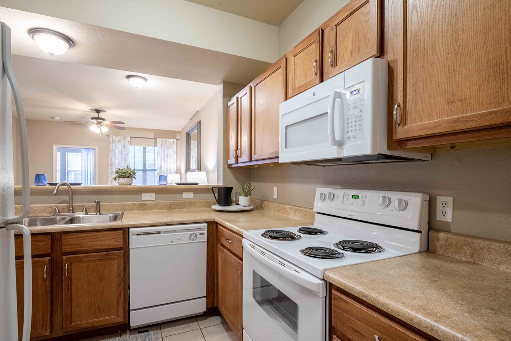 Kitchen with a sink and white appliances and wood cabinets