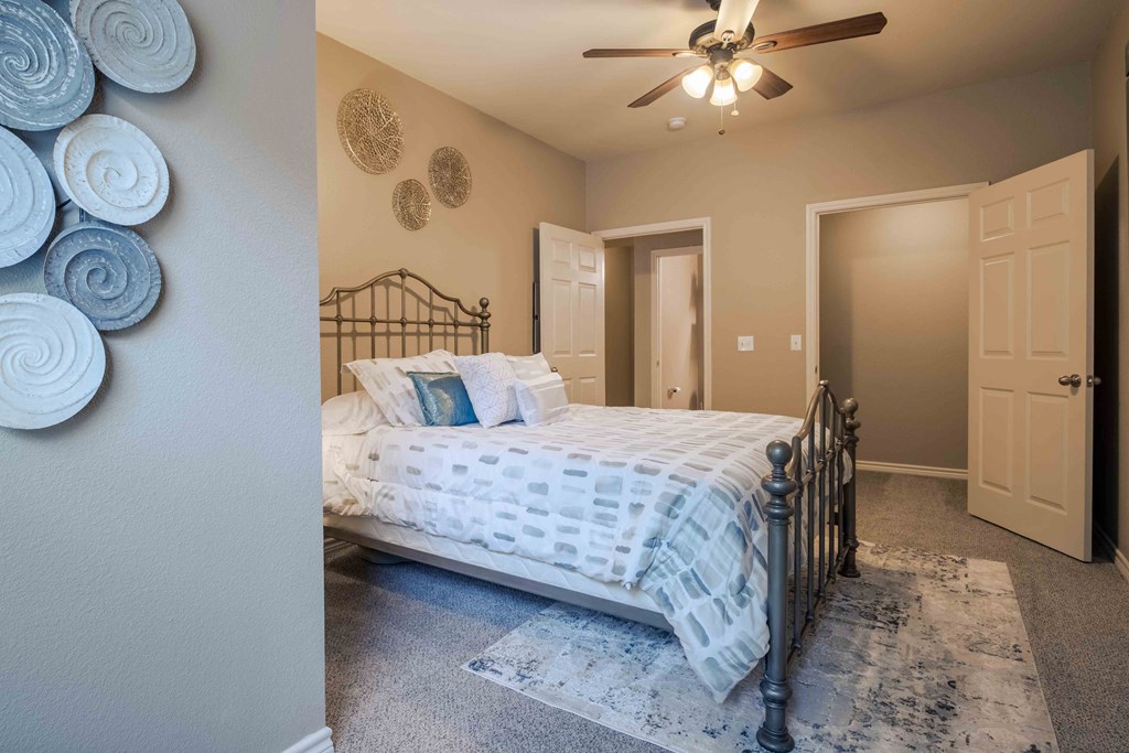 bedroom with a ceiling light/fan and carpet and doors