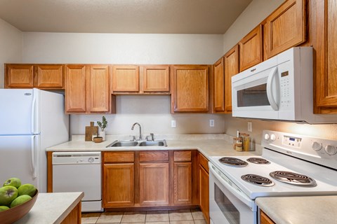 a kitchen with white appliances and wooden cabinets