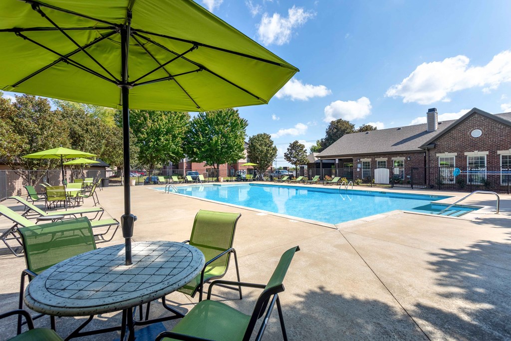 Apartments in Clarksville, TN for Rent - Parc at Clarksville - Luxury Swimming Pool with sundeck with chairs, patio table, and umbrella
