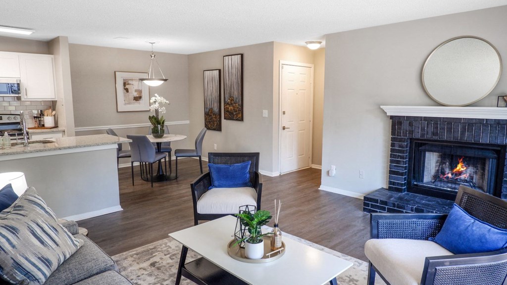 1 Park Central Apartments, Peachtree Corners, Georgia a living room with a fireplace and a kitchen in the background