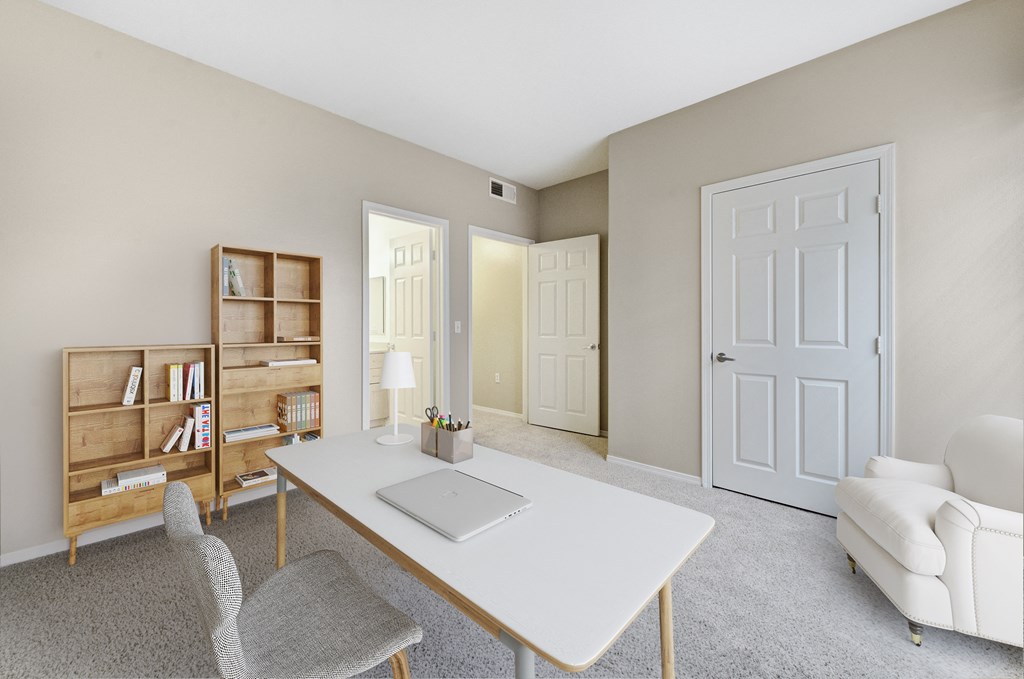 a home office with a white desk and a white chair