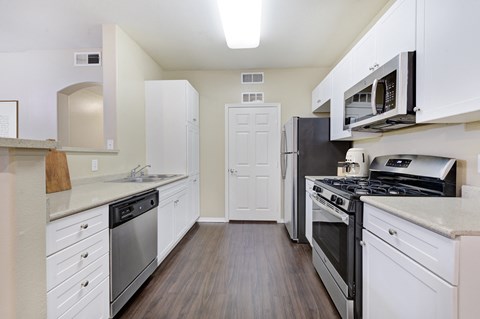 a kitchen with stainless steel appliances and white cabinets