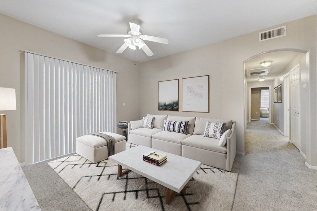 a living room with a couch and a coffee table and a ceiling fan