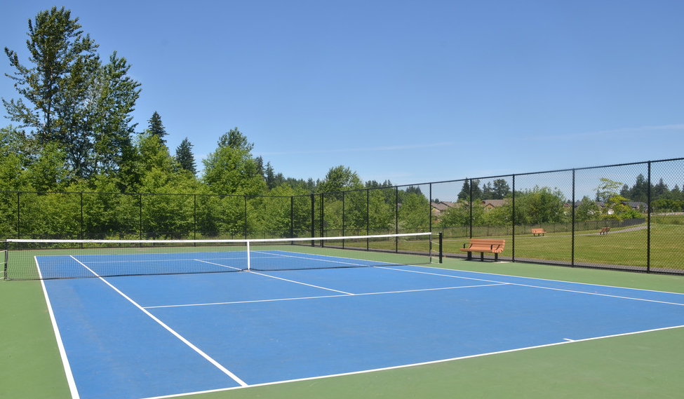 a tennis court with a fence and a bench