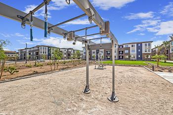 an empty playground in an urban park with apartments in the background