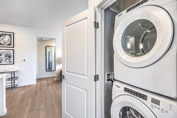 a front loading washer and dryer in a laundry room with a white door