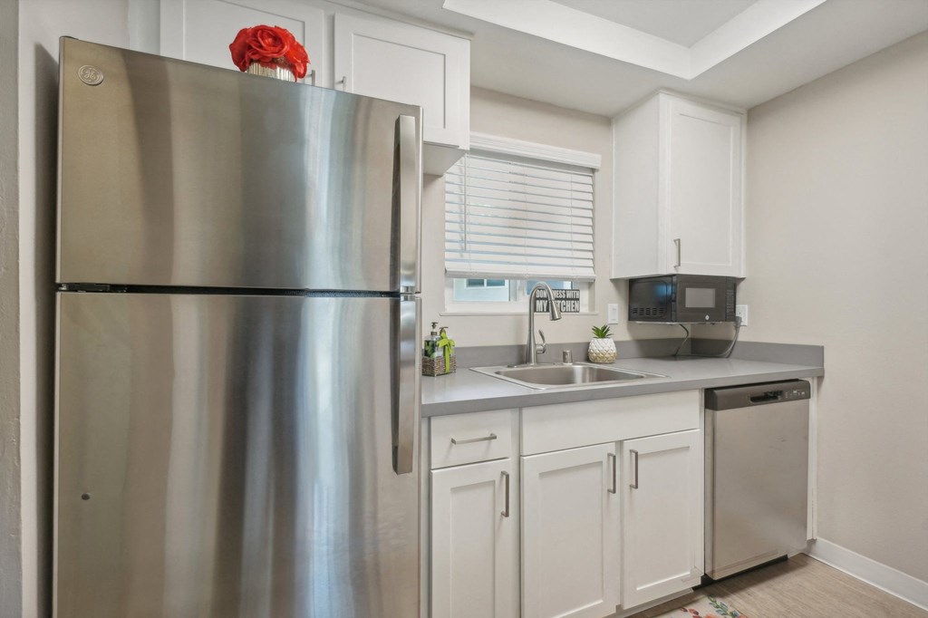 a kitchen with stainless steel appliances and white cabinets