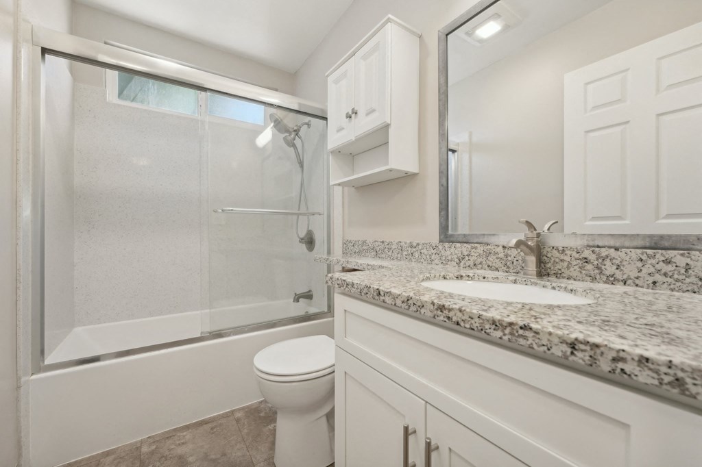 a bathroom with a shower toilet and sink