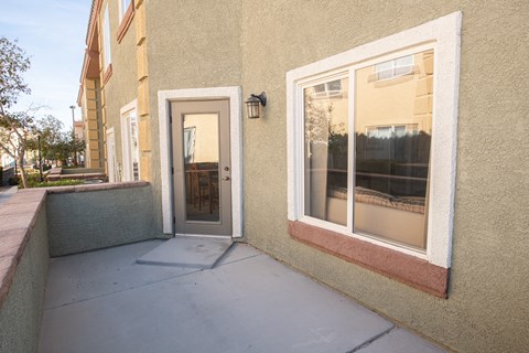 the front entrance of a building with a door and a patio