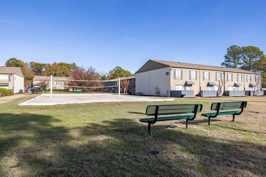 The Pearl at Highland Village Apartments and Townhomes for rent in Jackson, MS photo of two park benches in front of a volleyball court