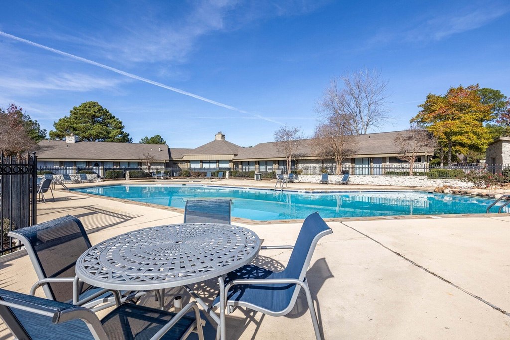 The Pearl at Highland Village Apartments and Townhomes for rent in Jackson, MS photo of resort style pool with chairs and tables