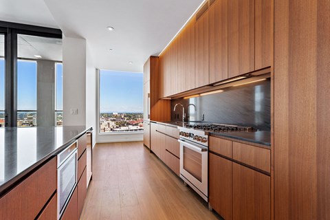 a kitchen with wooden cabinets and a view of the city