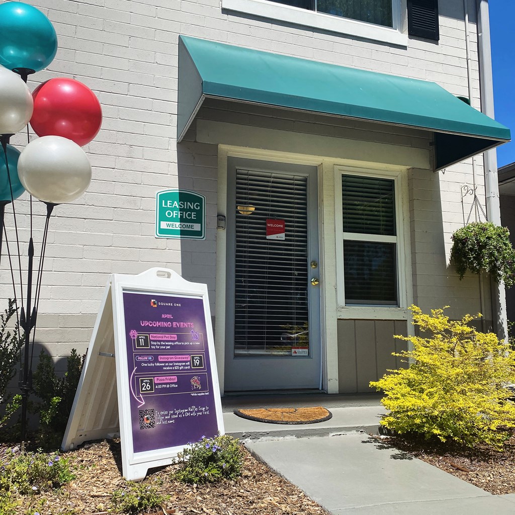 a building with a sign and balloons outside of it
