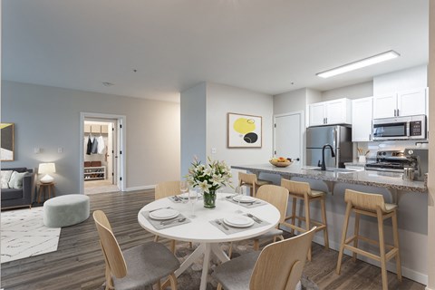 a living room and kitchen with a white table and chairs